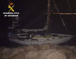 La Guardia Civil auxilia a dos personas y su perro en un velero encallado en las rocas de Almerimar