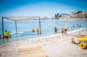 Ocho voluntarios atienden a bañistas con movilidad reducida en la playa adaptada de Aguadulce